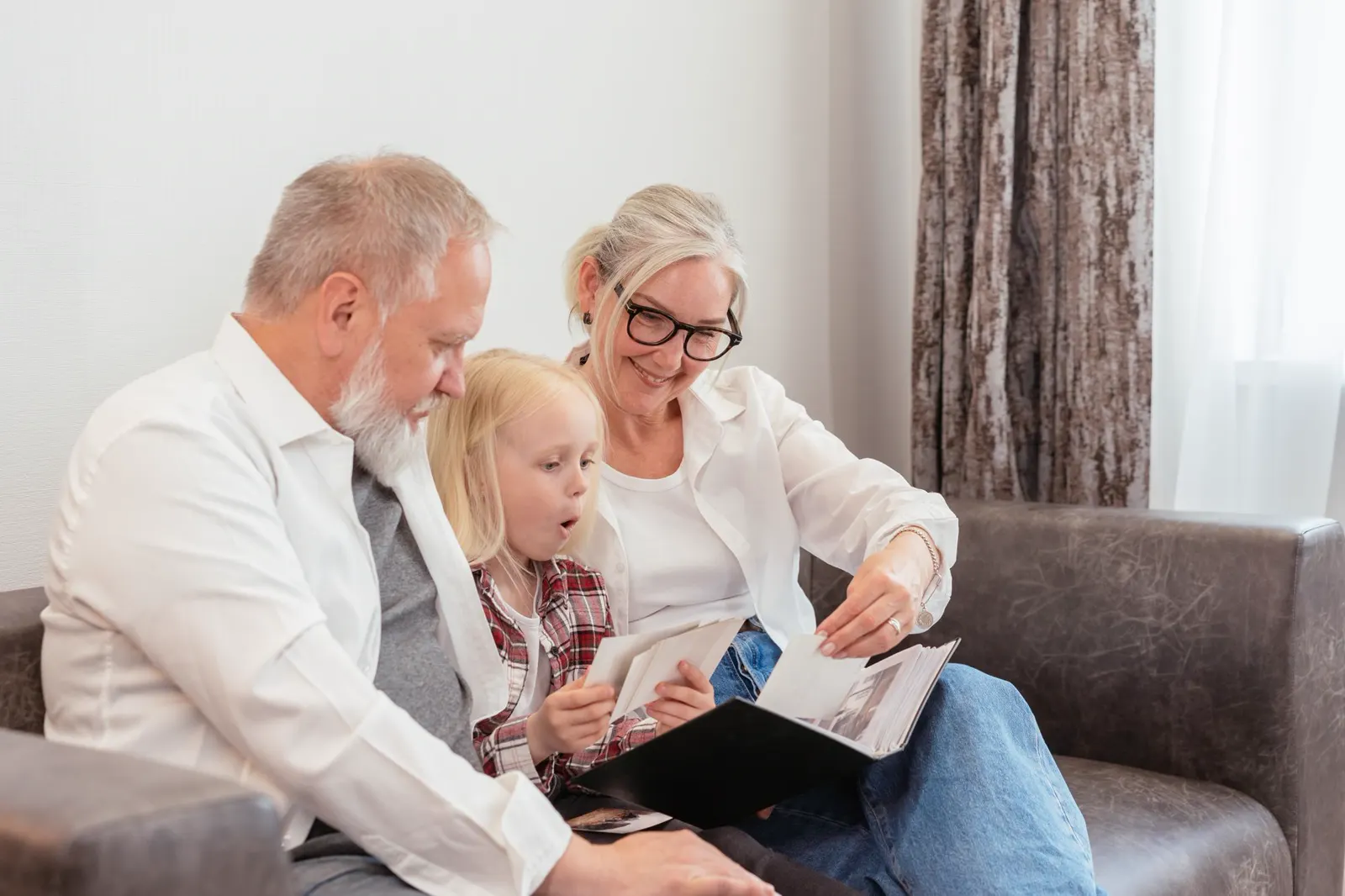 Grandparents and a young girl looking through photographs together