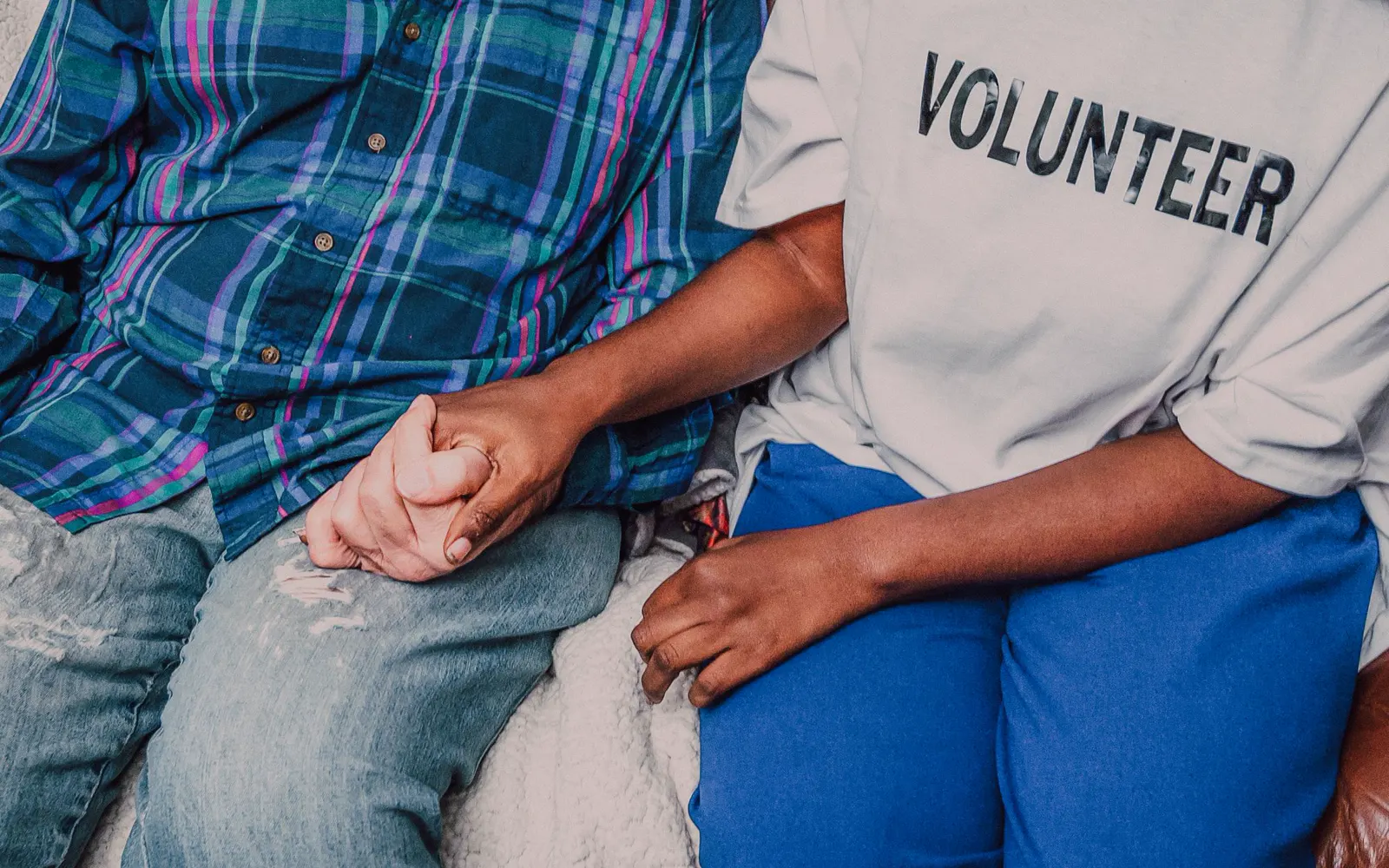 A volunteer holding an older person's hand